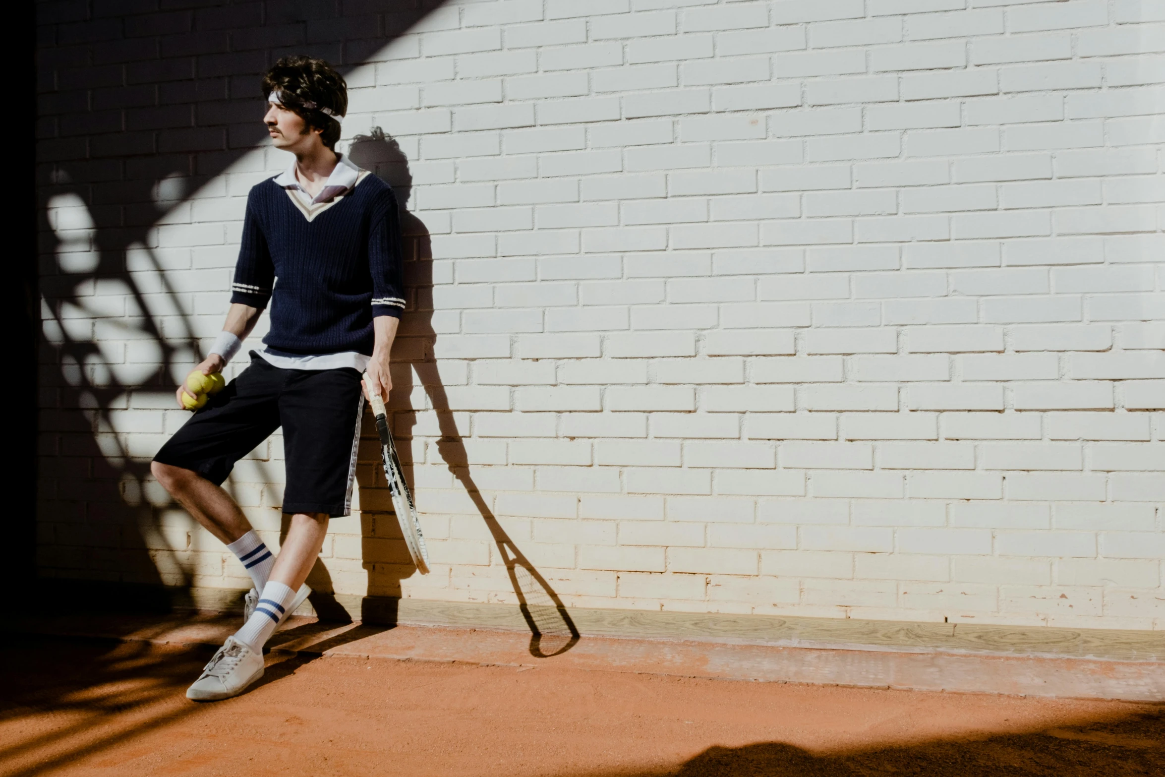 a man standing with a tennis racket and ball