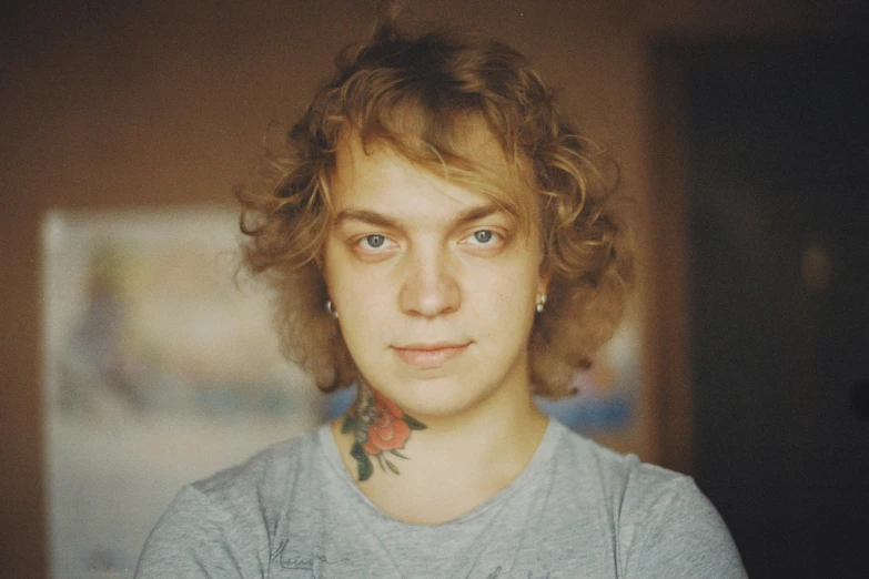 a young man wearing a tshirt and shirt with tattoos