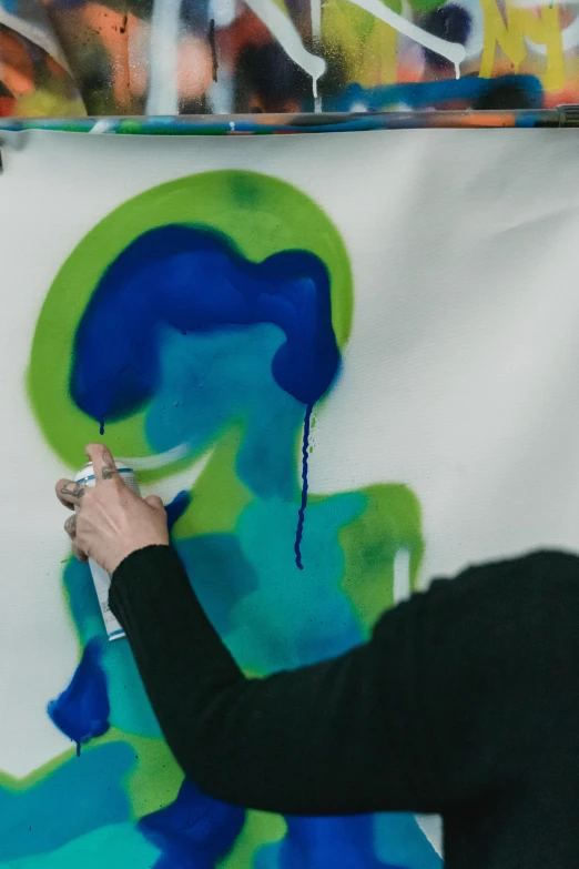 a painting being worked by a woman's hand