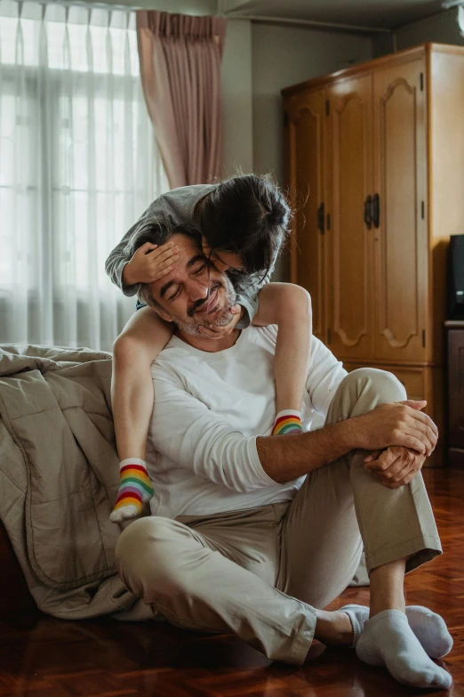 a man in white shirt and grey pants hugging woman