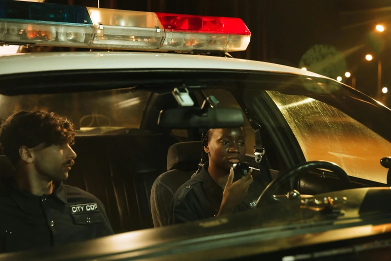 two men sitting in a police vehicle