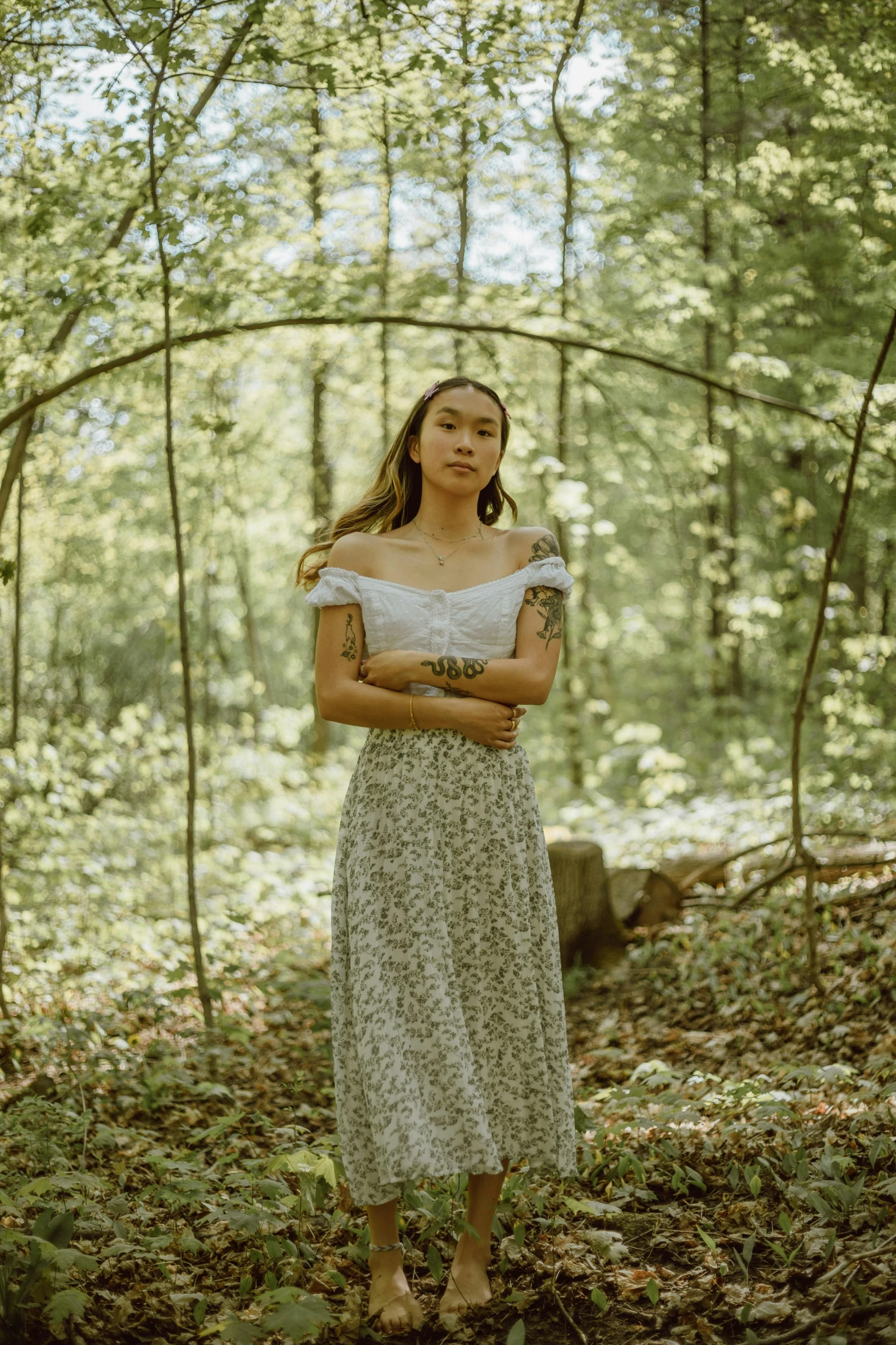 a woman in a dress standing in the forest