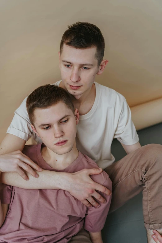 two young men sitting together posing for a po