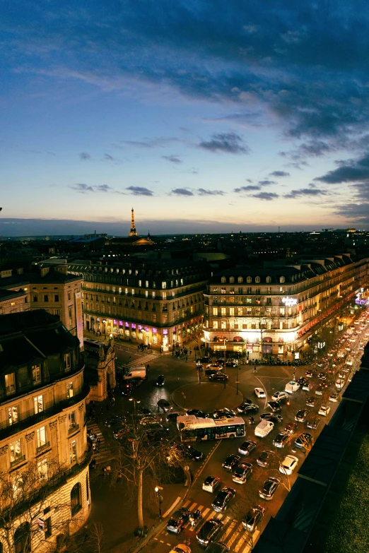 a city square and street with traffic at night