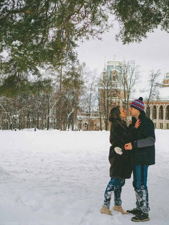 two people standing in the snow kissing