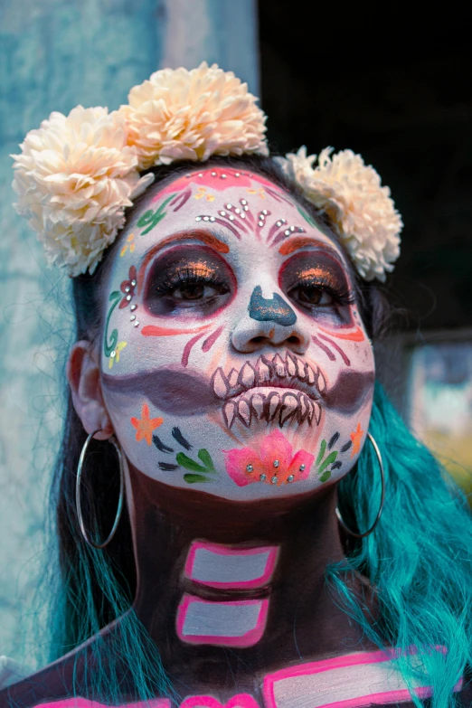 woman with multicolored makeup has flowers in her hair