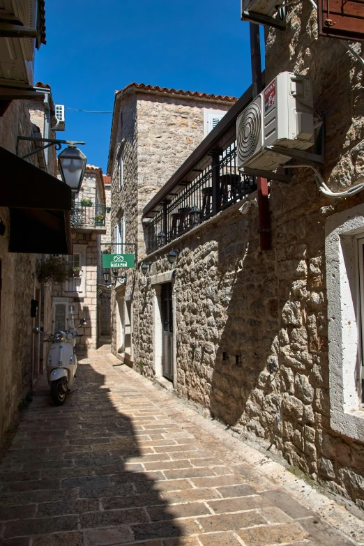 street lined with stone buildings and alleys beneath blue sky