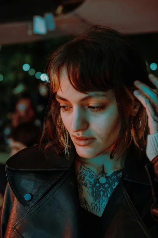 woman in leather coat using cellphone at night