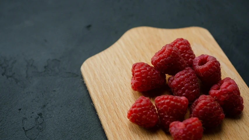 some raspberries are placed on top of a  board