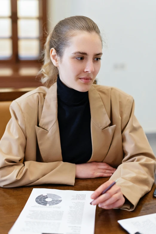 a  sits at a desk with papers and a pen