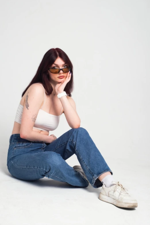 a young woman is posing for the camera in jeans and t - shirt