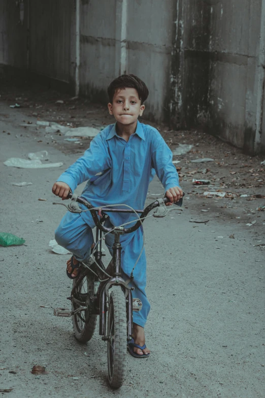 a  in blue riding on the front tire of a bicycle