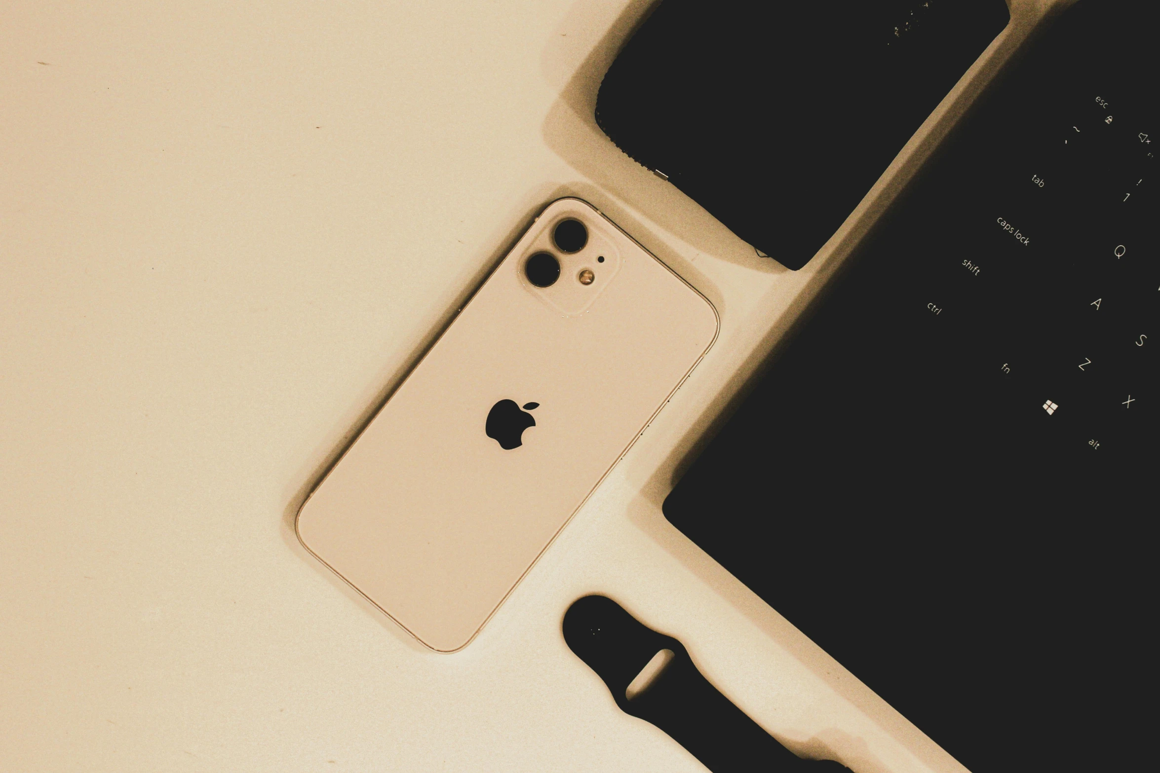 a white apple iphone next to a computer keyboard