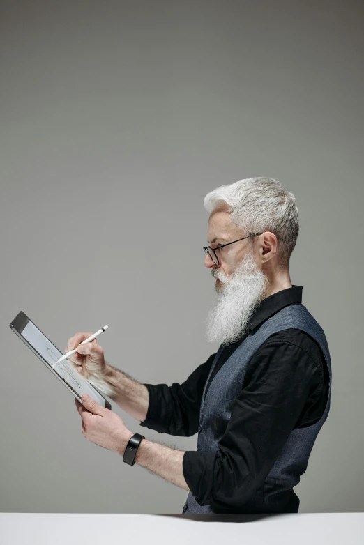 an older gentleman looking at a piece of paper with a long white beard