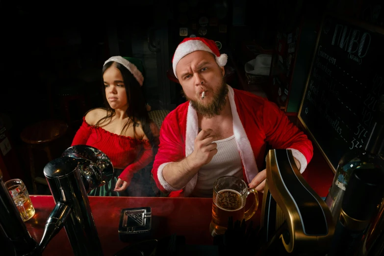 a couple of people in santa outfits sitting at a table