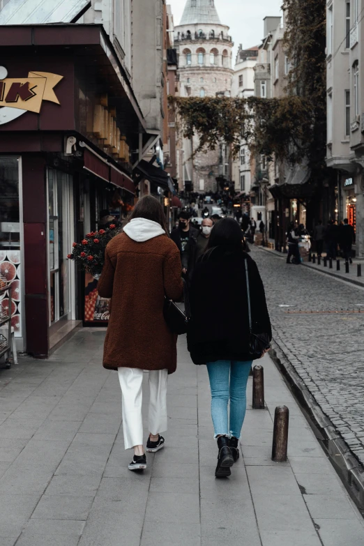 two people are walking down a brick walk way