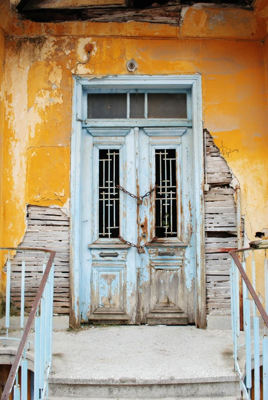 two doors on a building with the railings broken down