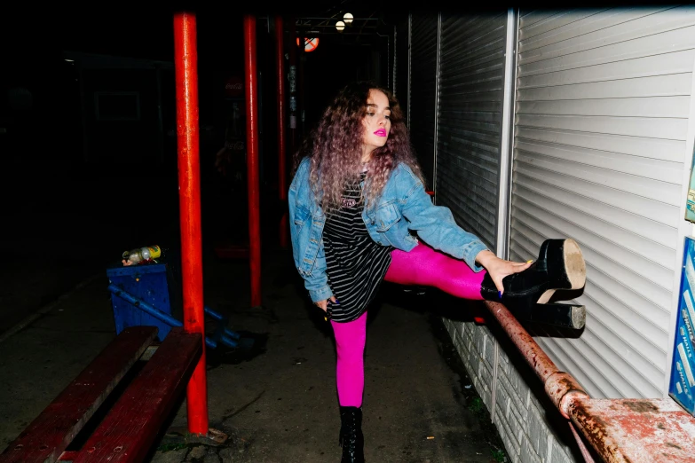 a woman sitting down leaning against a building