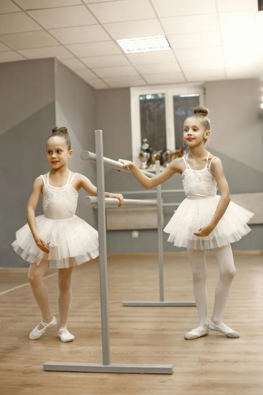 a couple of little girls are in ballet attire