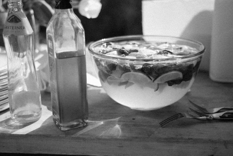 two glasses of water and two bottles of soda are sitting on the table