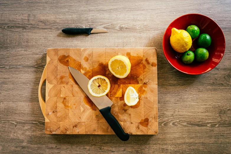 sliced citrus fruit and a  board and knife on wooden surface