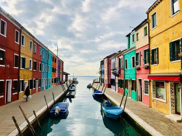 several boats are docked next to multi - colored buildings