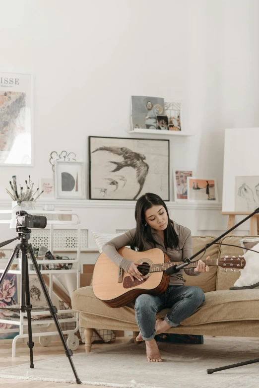 a person is playing an acoustic guitar in a room