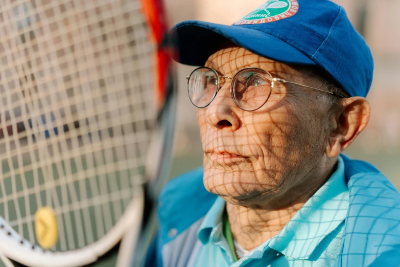 a man in a baseball cap is holding a tennis racket