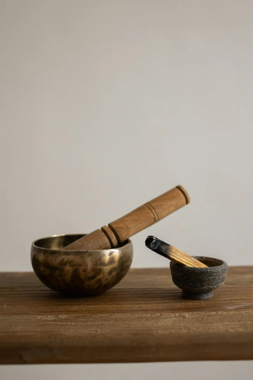 wooden mortar and spoon on wooden table near wall