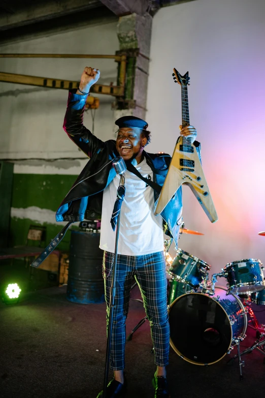 a woman standing on top of a stage holding two guitars