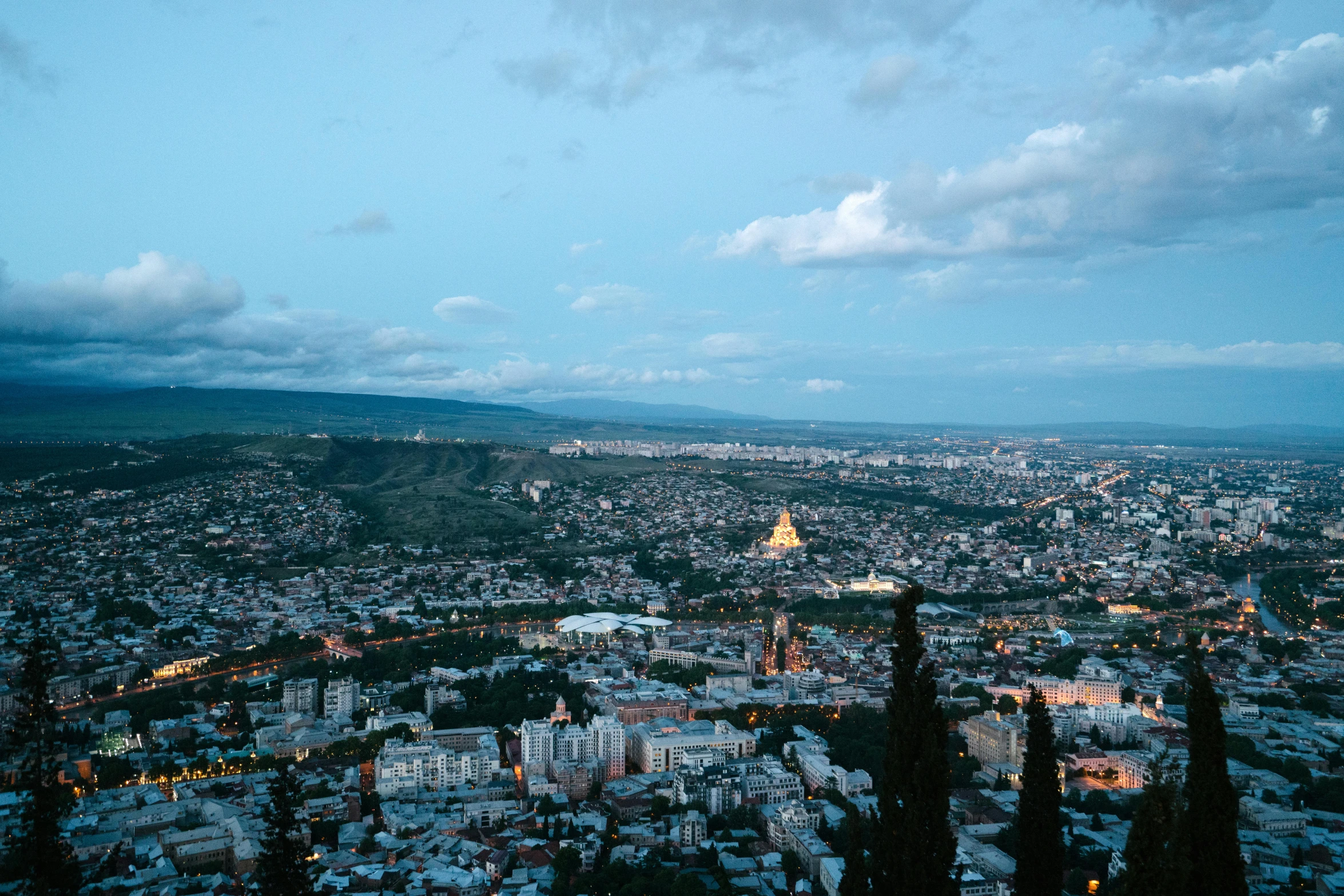 a view of the city and mountains from a hill