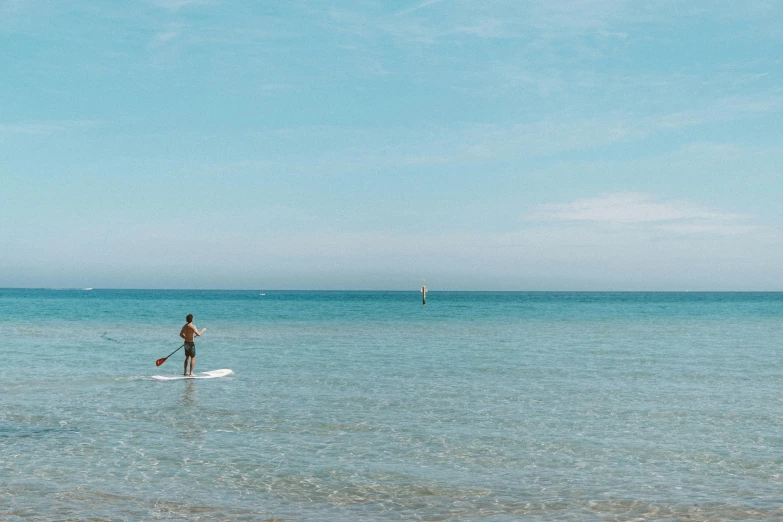 a man riding on the back of a paddle board