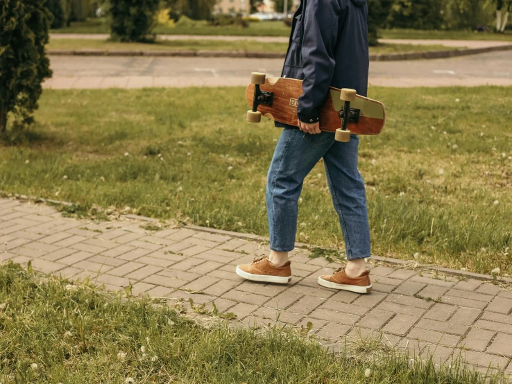 a man walking with a skateboard on his hand