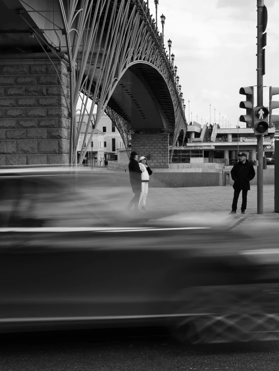 three people standing on the side of a street