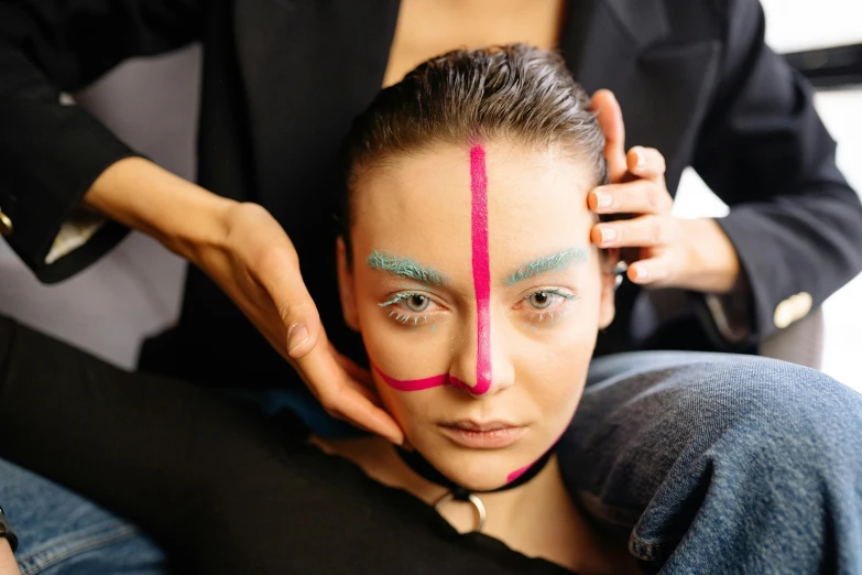 a woman sitting down while having her hair combed