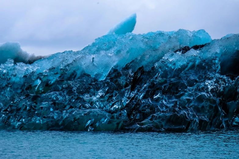 an icy glacier being whipped up from the water