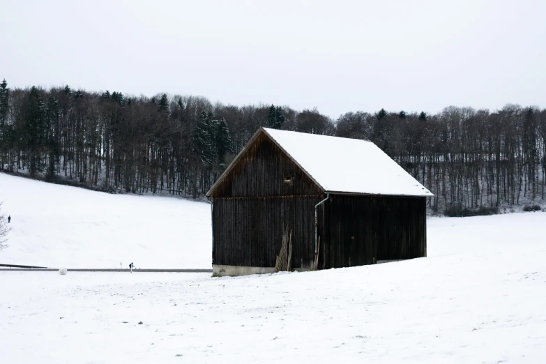 a barn sits on top of a snow covered slope