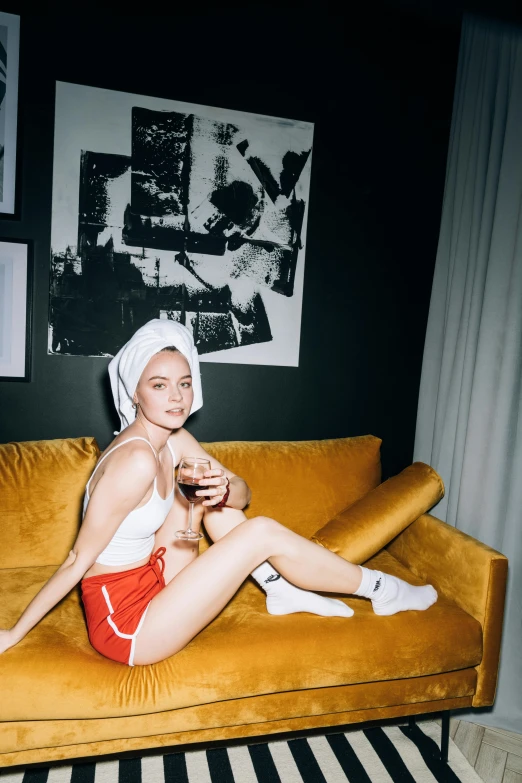 a beautiful young woman sitting on top of a yellow couch