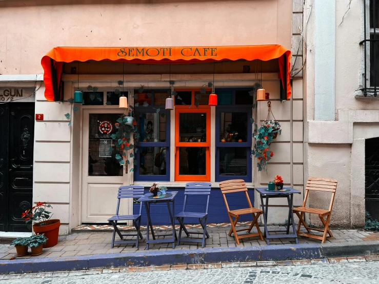 chairs and tables are outside a cafe