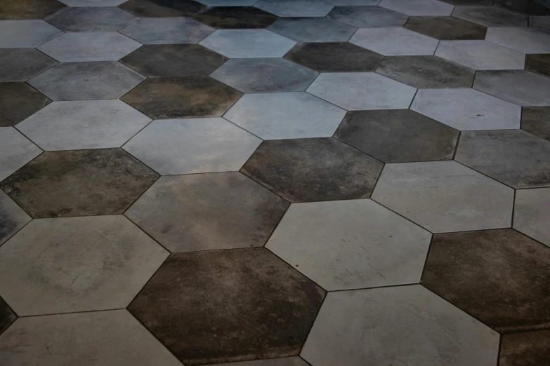 a floor made of hexagonal tiles with some dark spots on the sides