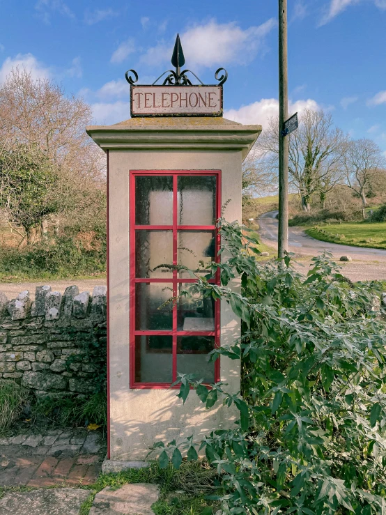 a telephone booth surrounded by bushes and trees