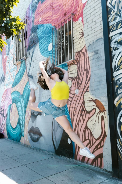 a woman leaning up against the side of a building