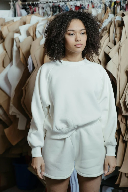 a woman standing in front of clothes racks