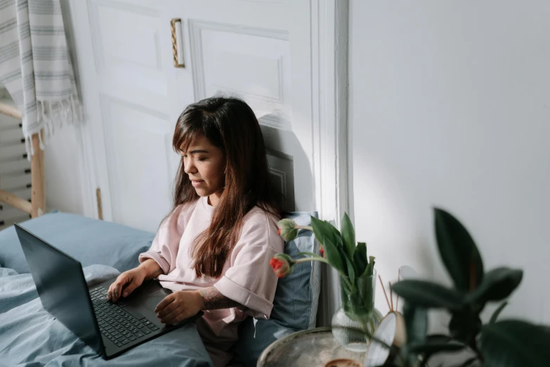 the girl sits with her laptop in front of her