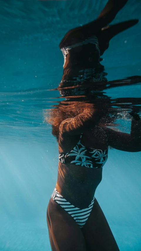 woman with red hair in a swimsuit under water