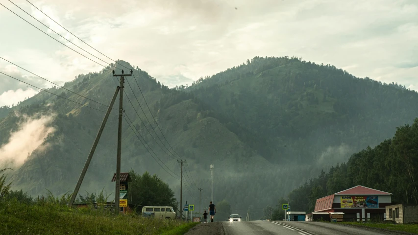 the view down a country road with a mountain in the background