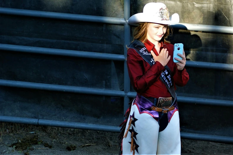 woman in a cowboy costume using a cell phone