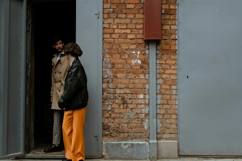 a man is standing at the door of a brick building