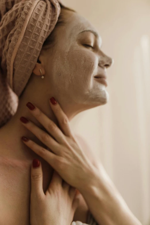 a woman with her face covered in white clay