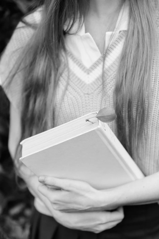 black and white po of woman holding a book